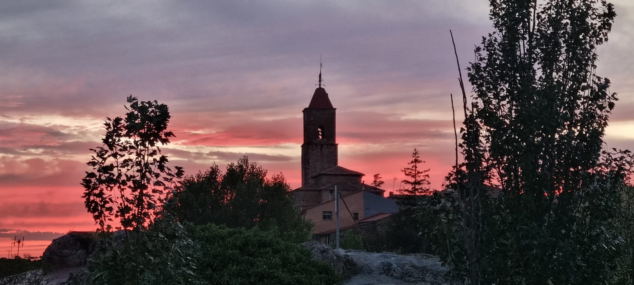 Puesta de sol con la torre de la iglesia al fondo